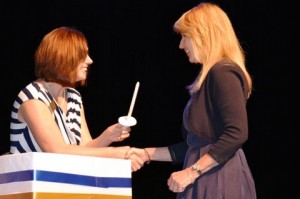 Catherine Page of Princeton receives her candle from advisor Stephanie Hall after signing the ceremonial guest book during the induction.