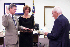 Newly elected town councilman Mark A. Petersen receives his oath of office from retired Superior Court Judge Knox Jenkins.