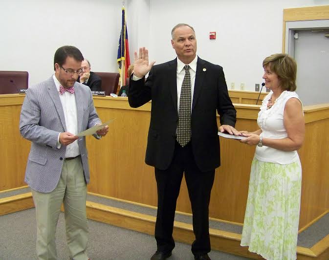 Smithfield town manager Michael Scott (center) takes his Oath of Office from Mayor Andy Moore (left) as Scott’s wife, Peggy, holds a Bible. JoCoReport.com Photo 